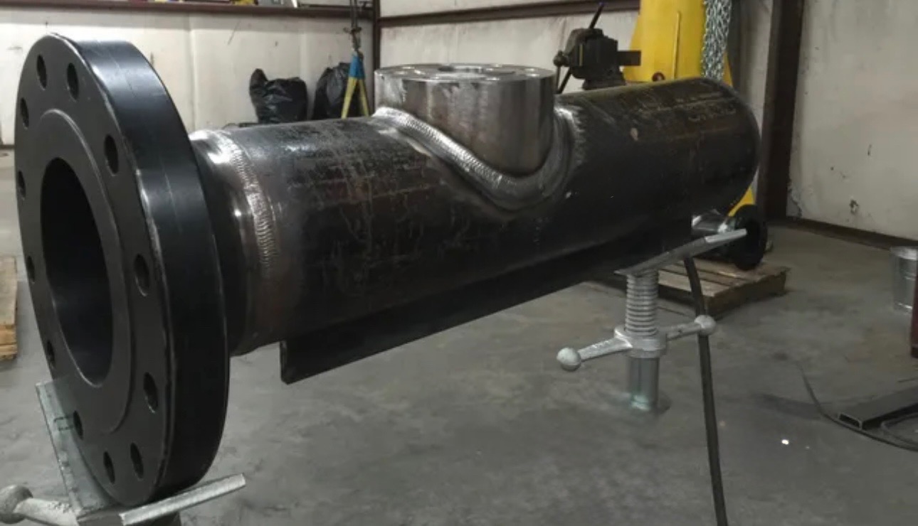 Custom fabricated carbon steel pipe spool featuring a large flange and heavy-duty reinforced branch connection