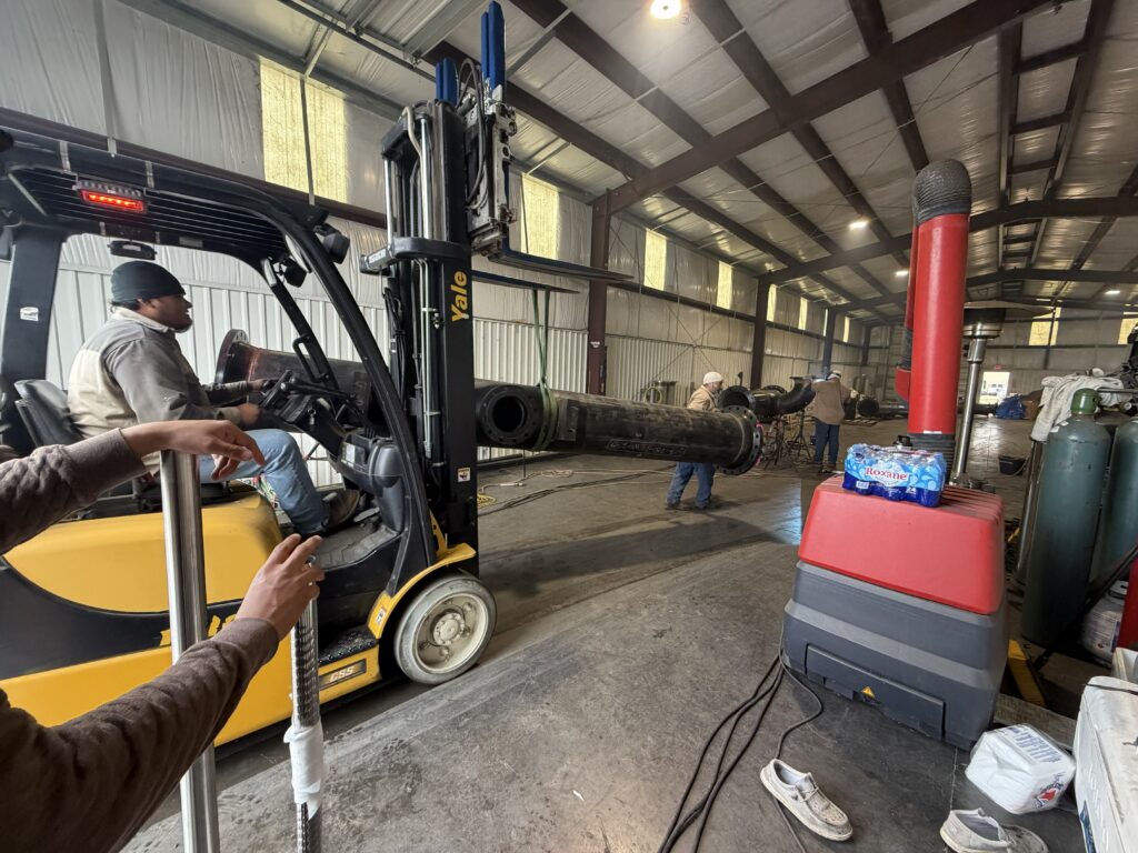 Heavy industrial pipe fabrication and material handling at a Houston welding facility.